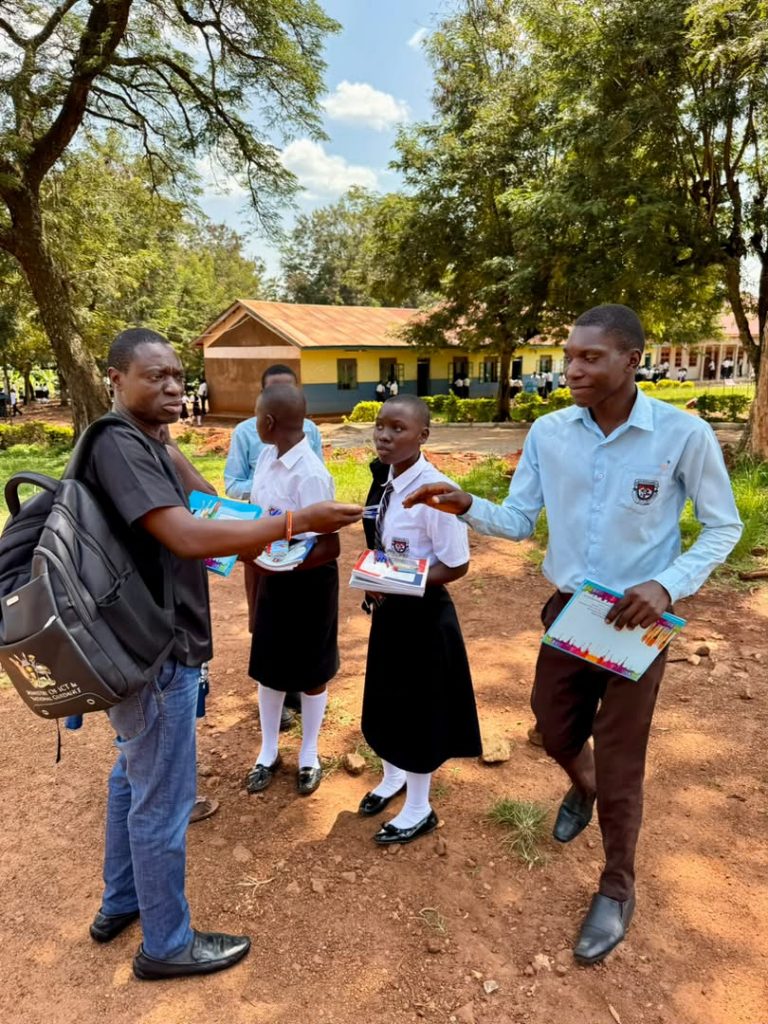 Student receiving school materials from an Ophelia Foundation representative