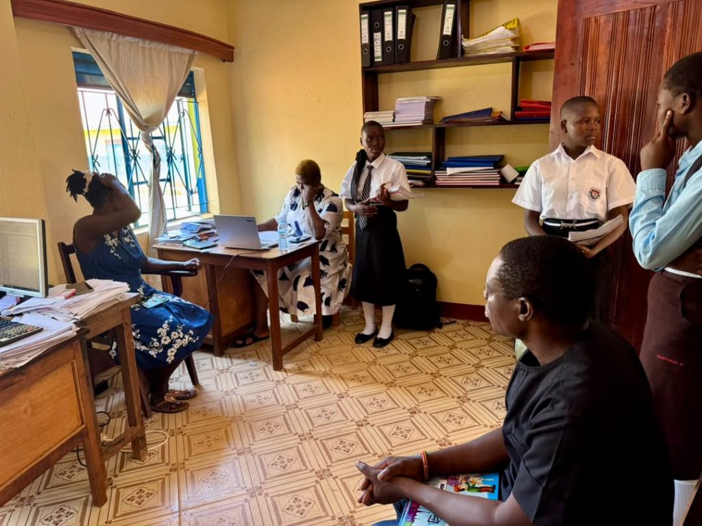 Foundation representatives and students meeting with school administrators inside an office