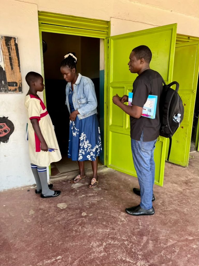 Foundation representatives speaking with a student outside a classroom with bright green doors