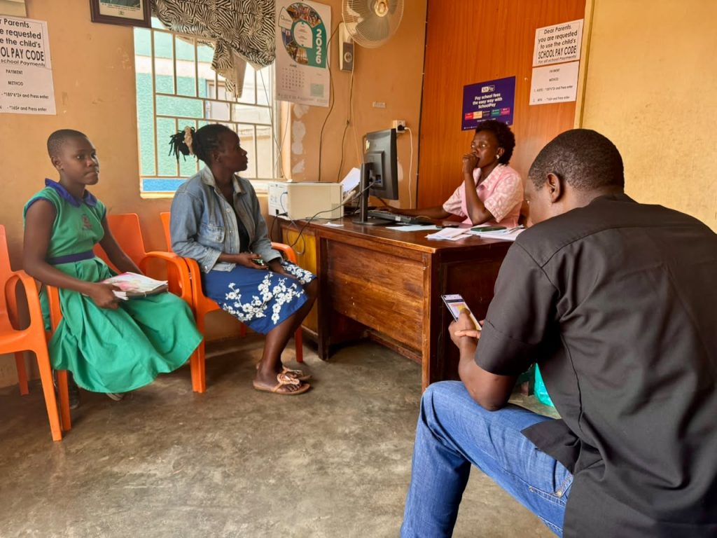 Foundation representatives meeting with a school administrator while a student holds her books