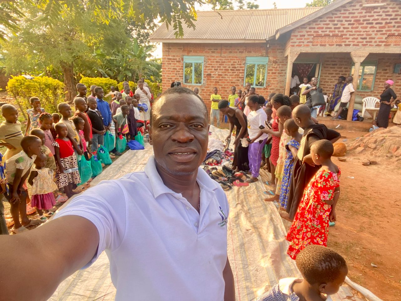 Johns Brown taking a photograph with children gathered during the Christmas celebration