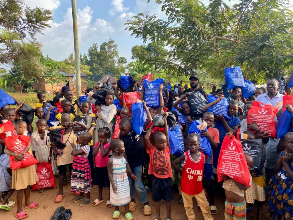 Children and adults celebrating together while holding Christmas packages