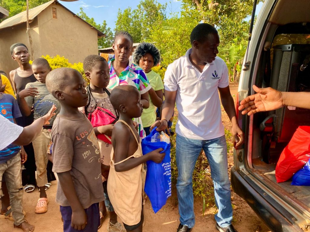 Children gathered near a vehicle while Christmas packages are distributed